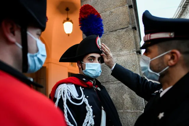 A Carabinieri officer arranges colleague's hat outside the theatre at the opening night of the La Scala opera house in Milan, Italy, December 7, 2021. (Photo by Flavio Lo Scalzo/Reuters)