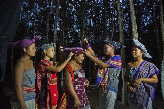 In this Monday, June 10, 2019 photo, Indian Rabha tribal girls adjust their traditional head gear during Baikho festival at Pantan village, west of Gauhati, India. Every year, the community in India’s northeastern state of Assam celebrates the festival, to please a deity of wealth and ask for good rains and a good harvest. (Photo by Anupam Nath/AP Photo)