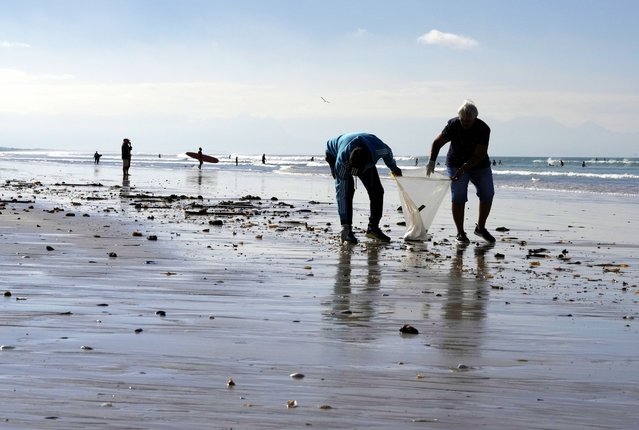 People join a public clean-up operation on 'Earth Day' at the Muizenberg beach, in Cape Town, South Africa, Monday, April 22, 2024 . (Photo by Nardus Engelbrecht/AP Photo)