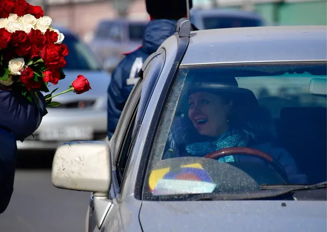 A traffic policeman congratulates a female driver on upcoming International Women's Day in the citys Central Square in Vladivostok, Russia on March 7, 2017. (Photo by Yuri Smityuk/TASS via Getty Images)