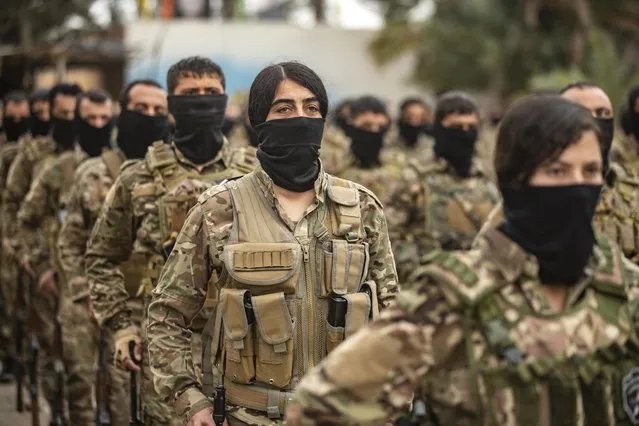 Fighters of the Kurdish-led Syrian Democratic Forces (SDF) take part in a military parade in the US-protected Al-Omar oil field in the eastern province of Deir Ezzor on March 23, 2021, marking the second annual anniversary of Baghouz's liberation from the Islamic State (IS) group. Islamic State forces remain as dangerous today as when they were ousted from their last Syrian bastion two years ago, Kurdish forces warned as they marked the anniversary. (Photo by Delil Souleiman/AFP Photo)