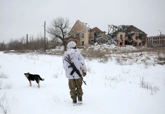 A Ukrainian Military Forces serviceman walks in the village of Pesli, in the eastern Ukraine self-proclaimed Donetsk People's Republic (DPR), close to the front-line with Russia-backed separatists on January 25,2022. (Photo by Anatolii Stepanov/AFP Photo)