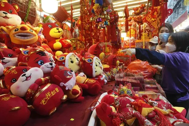 People purchase Chinese New Year decorations at a market to celebrate the Lunar New Year in Hong Kong, Monday, January 31, 2022. The Chinese Lunar New Year falls on Feb. 1. (Photo by Vincent Yu/AP Photo)