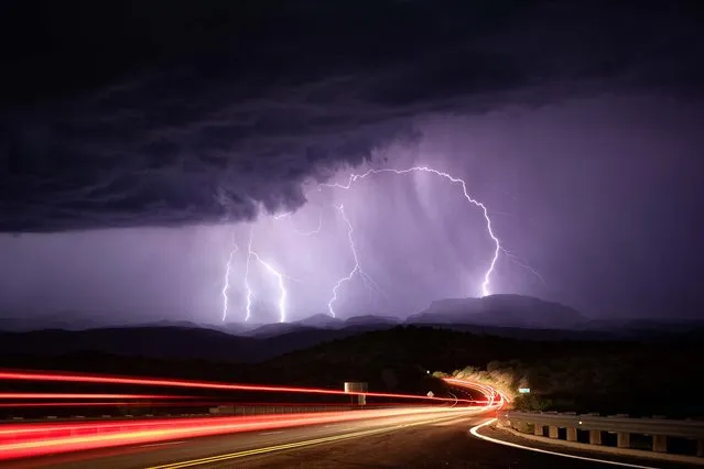 Light trails from passing cars pictured with heavy lightning in the distance, taken along highway 77 near Mammoth, Arizona in July 2012. (Photo by Mike Olbinski/Barcroft Media)