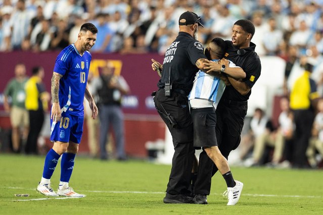 A pitch invader approaches Lionel Messi #10 of Argentina as they are stopped by security in the second half during an International Friendly between Guatemala and Argentina at Commanders Field on June 14, 2024 in Landover, Maryland. (Photo by Simon Bruty for The Washington Post)