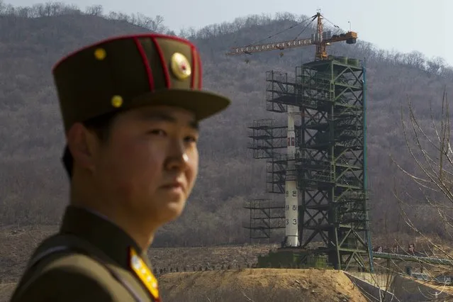In this April 8, 2012, file photo, a soldier stands in front of the Unha-3 rocket at a launching site in Tongchang-ri, North Korea. North Korea is reportedly restoring facilities at its long-range rocket launch site that it had dismantled as part of disarmament steps last year. A major South Korean newspaper reports that the country's spy service gave such an assessment to lawmakers in a private briefing on Tuesday. (Photo by David Guttenfelder/AP Photo)
