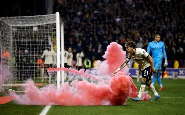 Kostas Tsimikas is startled by a flare thrown on to the pitch during Liverpool's FA Cup quarter-final match against Nottingham Forest in Nottingham, Britain on March 20, 2022. (Photo by Craig Brough/Reuters)