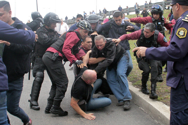 Sergio Berni, the security minister for the Buenos Aires province, center right, is separated from an attacker, below, during a protest in Buenos Aires, Monday, April 3, 2023. Berni was attacked during a protest by bus drivers after the murder of a co-worker while on the job. (Photo by Andres Pelozo/AP Photo)