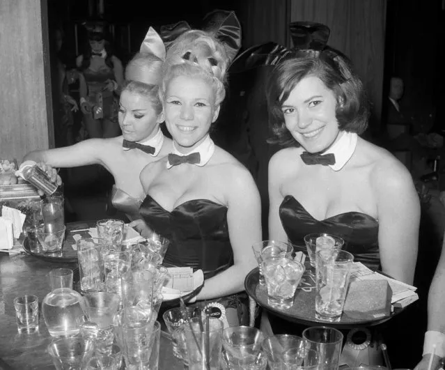 In this January 15, 1963 file photo, Playboy Bunnies Elka Hellmann, from left, Monica Schaller and Sabrina Scharf serve drinks at New York's Playboy Club. The tightly corseted Playboy Bunnies, with rabbit tails and ears, will soon be back in business in New York City. Three decades after the original Playboy Club closed in Manhattan, a new club will debut later this year in a hotel a few blocks from Times Square. (Photo by John Lent/AP Photo)