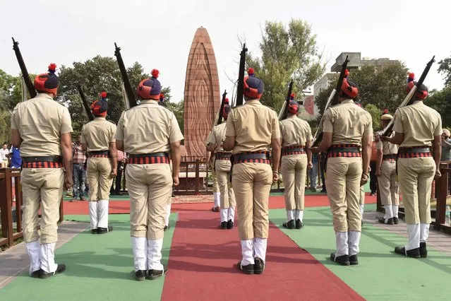 Police present arms as they pay tribute on the occasion of 103rd anniversary of the Jallianwala Bagh massacre in Amritsar on April 13, 2022. (Photo by Narinder Nanu/AFP Photo)