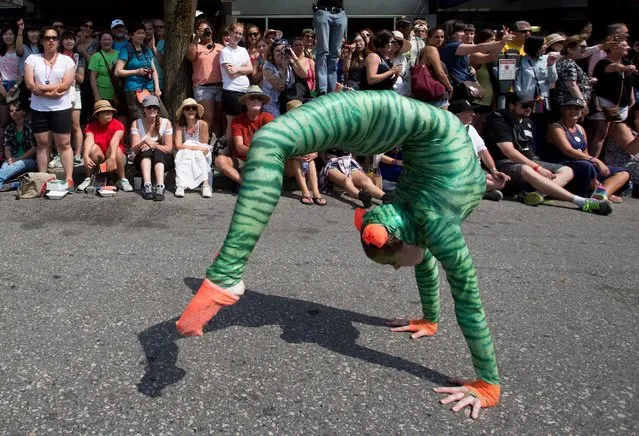 A woman performs a flip while marching in the Vancouver Pride Parade in Vancouver, British Columbia, Sunday, August 2, 2015. (Photo by Darryl Dyck/The Canadian Press via AP Photo)