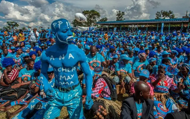 A supporter painted in blue, the colour of Malawi’s ruling party, dances in front of a crowd of supporters during the official launch of the Democratic Progressive Party's (DPP) manifesto and election campaign on April 7, 2019, at Kamuzu Institute for Sports in Malawi's capital Lilongwe, ahead of next month’s elections. Mutharika, who has been in power since 2014, will face tough opposition, including from his own deputy Saulos Chilima, at the May 21 election. (Photo by Amos Gumulira/AFP Photo)