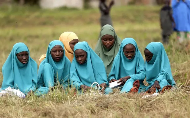Muslims girls look on during Eid al-Fitr prayers in an outdoor open area in Lagos, Nigeria, Monday, May 2, 2022, at the end of the holy month of Ramadan. (Photo by Sunday Alamba/AP Photo)