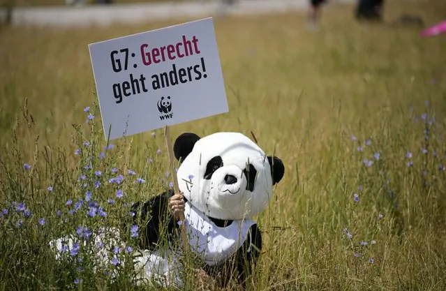 A protestor dressed as a panda bear holds a sign which reads 'Justice is different' during a demonstration ahead of the G7 meeting in Munich, Germany, Saturday, June 25, 2022. The G7 Summit will take place at Castle Elmau near Garmisch-Partenkirchen from June 26 through June 28, 2022. (Photo by Martin Meissner/AP Photo)