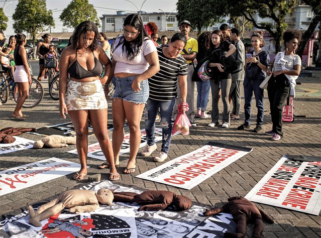 People read signs placed on the ground during a protest against a police raid that killed more than a dozen of people in Guaruja, Sao Paulo state, Brazil, Wednesday, August 2, 2023. The death toll from the raid has climbed to at least 14, in a sprawling operation that has raised questions about the use of lethal force by police. (Photo by Tuane Fernandes/AP Photo)