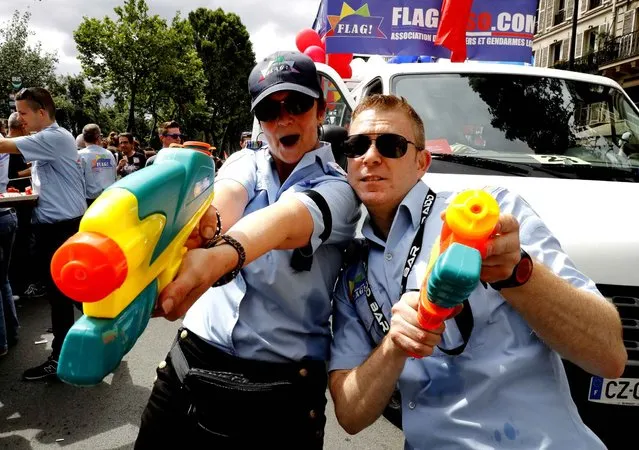 Costumed participants from the association for gay police and gendarmes (FLAG) pose for photographs during the “Gay Pride” parade in Paris on July 2, 2016. (Photo by Francois Guillot/AFP Photo)