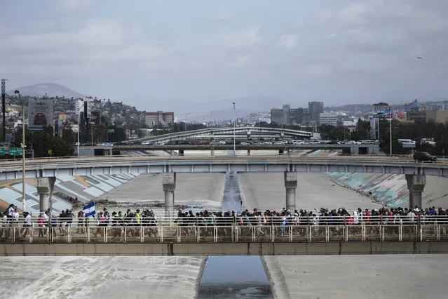 In this April 29, 2018 photo, Central Americans who travel with a caravan of migrants they walk towards the border before crossing the border and request asylum in the United States, in Tijuana, Mexico. The group that led a monthlong caravan of Central Americans seeking asylum in the United States wanted to draw attention to the plight of people in the violent region. (Photo by Hans-Maximo Musielik/AP Photo)