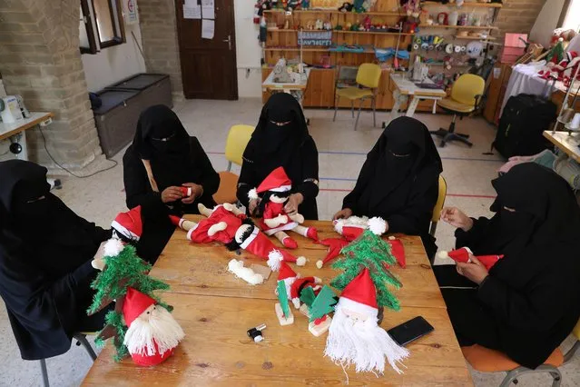 Palestinian women wearing face veil, niqab, make Santa-themed Christmas toys in the northern Gaza Strip on December 29, 2019. (Photo by Mohammed Salem/Reuters)