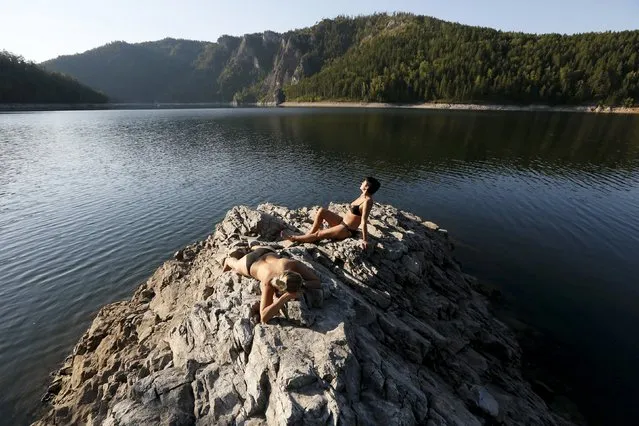 Two women sunbathe on a bank of the Yenisei River in the Siberian Taiga area outside Krasnoyarsk, Russia, August 31, 2015. (Photo by Ilya Naymushin/Reuters)