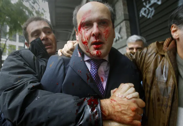 Former conservative minister Kostis Hatzidakis is covered with blood after about 200 leftists attacked him with stones and sticks, shouting: “Thieves! Shame on you!” in central Athens December 15, 2010. (Photo by Yannis Behrakis/Reuters)
