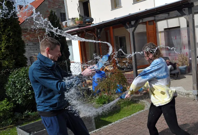 A Polish girl and a boy throw water over each other on Wet Monday in Szczecin, northwestern Poland, 13 April 2020. Wet Monday is a Catholic celebration held on Easter Monday mostly in Poland, but also in the Czech Republic, Slovakia, Hungary and some parts of western Ukraine. Due to the lockdown it is forbidden to celebrate this holiday in public. (Photo by Marcin Bielecki/EPA/EFE)