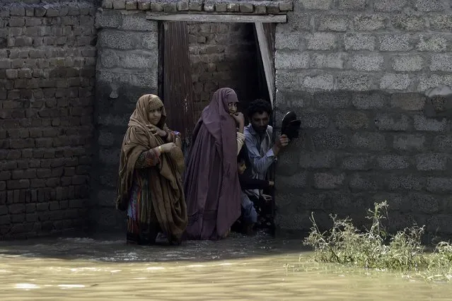 Stranded residents prepare to leave their flooded home following heavy monsoon rains in Charsadda district of Khyber Pakhtunkhwa on August 29, 2022. The death toll from monsoon flooding in Pakistan since June has reached 1,061, according to figures released on August 29, 2022, by the country's National Disaster Management Authority. (Photo by Abdul Majeed/AFP Photo)