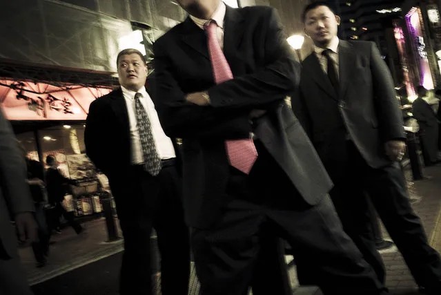 Members pose in the streets of Kabukicho, the red light district in the heart of Shinjuku, Tokyo, Japan. By always wearing tailored suits, the Yakuza attempt to spread an image of decency and conformity. But the underlying tension unmistakibly remains. Obvious influences are American gangster icons from the early 20th century, like John Dillinger – 2009. (Photo and caption by Anton Kusters)