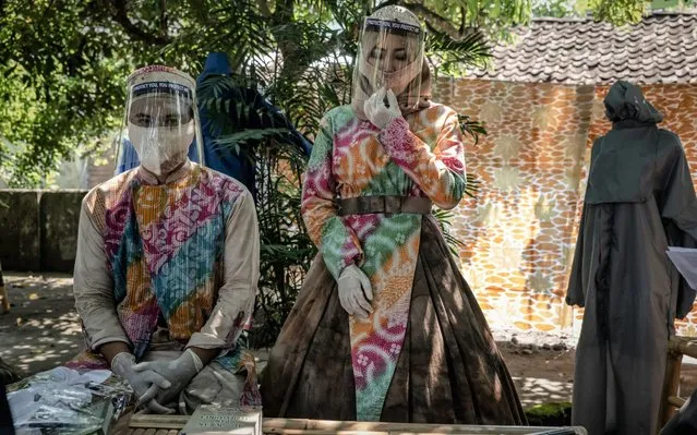 Groom Tunggul Pujangkoro and his bride Novi rahmawati wear a mask and face shield during their wedding ceremony amid the coronavirus pandemic at the Religious Affairs office in Banguntapan on May 8, 2020 in Yogyakarta, Indonesia. Indonesia is struggling to contain hundreds of new daily cases of coronavirus with officials so far confirming over 13,000 cases of COVID-19 in the country with at least 943 recorded fatalities. The coronavirus (COVID-19) pandemic has spread to at least 200 countries and territories around the world, claiming over 270,000 lives and infecting over 3.8 million. (Photo by Ulet Ifansasti/Getty Images)