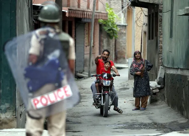 Indian paramilitary soldiers stop a man on a motor bike during curfew like restriction in downtown area of Srinagar, the summer capital of Indian Kashmir, 11 August 2016. According local news reports curfew and protest shutdown continued to paralyse life in Indian Kashmir for the 34 consecutive days. Around 55 have been killed and more than 6000 injured during the past month following the protests over the killing of Hizb-ul-Mujahideen commander, Burhan Muzaffar Wani and his two associates in a gunfight on 08 July 2016. (Photo by Farooq Khan/EPA)