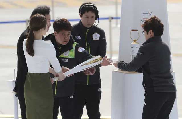 South Korean Prime Minister Lee Nak-yon, rear left, and former South Korean Olympic figure skating champion Yuna Kim, left, light an Olympic torch during the Olympic Flame Arrival ceremony at Incheon International Airport in Incheon, South Korea, Wednesday, November 1, 2017. (Photo by Lee Jin-man/AP Photo)