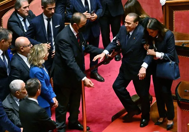 Leader of the Italian right-wing party “Forza Italia” (FI), Silvio Berlusconi (C) is helped during the vote for the new president of the Senate following the general elections, on October 13, 2022. Italian Senators and Deputies meet for the first time October 13, 2022, since elections to elect the new Presidents of the Parliament and the Senate. (Photo by Andreas Solaro/AFP Photo)