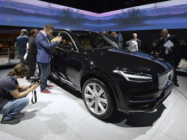 People take pictures of the new Volvo XC90 at the 2014 Paris Auto Show on October 2, 2014 in Paris, on the first of the two press days. (Photo by Miguel Medina/AFP Photo)