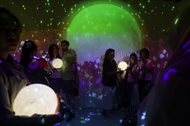 People attend “MOONLAB”, an intergalactic art exhibition and installation, in Bangkok, Thailand, on March 16, 2025. (Photo by Chalinee Thirasupa/Reuters)