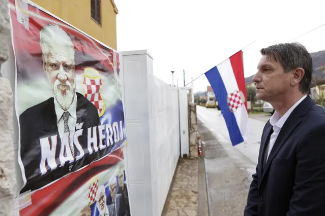 Bosnian Croat man Pero Pervisic , 49, friend of late Gen. Praljak, pays his respect in front of house where Gen. Slobodan Praljak was born, on the house are placed posters reading “Our Hero”, in southern Bosnian town of Capljina 170 kms south of Sarajevo, on Thursday, November 30, 2017. Gen. Praljak took his own life during sentence reading before The International War Crimes Tribunal in The Hague. Praljak was standing trial for war crimes committed in the name of Bosnian Croats, during 1992-95 war. (Photo by Amel Emric/AP Photo)