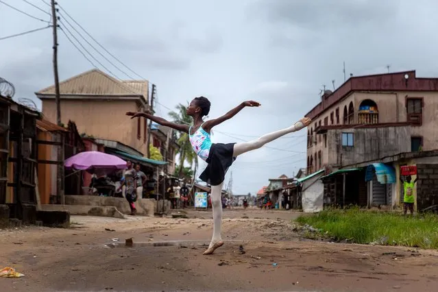 A student of the Leap of Dance Academy, Precious Duru, performs a dance routine in Okelola street in Ajangbadi, Lagos, on July 3, 2020. The Leap of Dance Academy is a ballet school in a poor district of sprawling megacity of Lagos that aims to bring classical dance to underprivileged children in Africa's most populous nation. The school is the brainchild of self-taught ballet lover Daniel Ajala, who opened its doors in late 2017 after studying the dance moves online and in books. (Photo by Benson Ibeabuchi/AFP Photo)