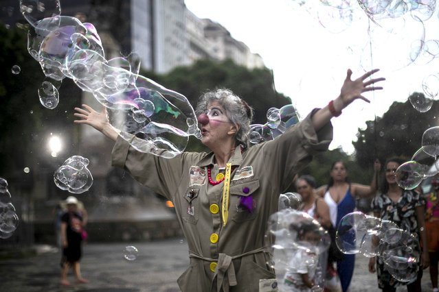 An artist dressed as a clown performs during a protest against the death of Venezuelan artist Julieta Hernández and violence against women, in Rio de Janeiro, Brazil, Friday, January 12, 2024. The body of Hernández, who had been missing since Dec. 23 while traveling by bicycle, was found by the police in the backyard of the home of the couple accused of killing her. (Photo by Bruna Prado/AP Photo)