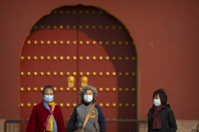 People wearing face masks walk at the Temple of Heaven in Beijing, Saturday, November 12, 2022. (Photo by Mark Schiefelbein/AP Photo)
