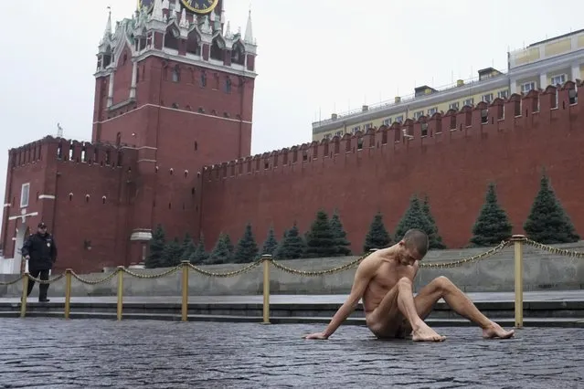 Artist Pyotr Pavlensky sits on the pavestones of Red Square during a protest action in front of the Kremlin wall in central Moscow November 10, 2013. (Photo by Maxim Zmeyev/Reuters)