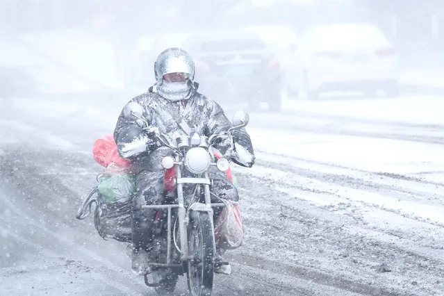 A motorcyclist rides amid snow in Dalian, Liaoning province, China December 16. 2017. (Photo by Reuters/China Stringer Network)