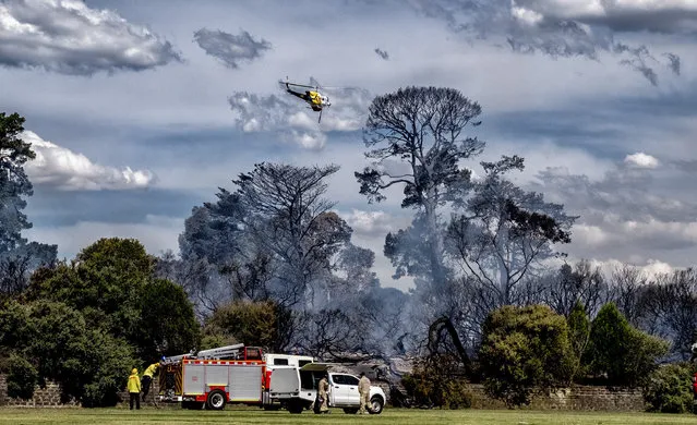 A water bomber helicopter approaches a fire burning at Cheltenham Park in Cheltenham, south-east of Melbourne, Victoria, Australia, 27 December 2017. According to reports, at least 40 homes were evacuated in the Melbourne's south-east after a grassfire started to burn in Cheltenham Park. Firefighters were said to have tackled the blaze and keep it under control. The cause of the fire is yet unknown. (Photo by Luis Enrique Ascui/EPA/EFE)