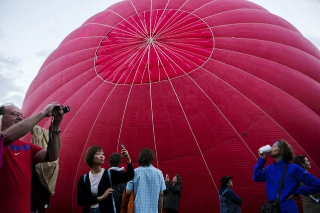 Attendees watch and photograph as hundreds of hot air balloons lift off on the first day of the 2015 Albuquerque International Balloon Fiesta in Albuquerque, New Mexico, October 3, 2015. (Photo by Lucas Jackson/Reuters)