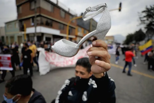 A shoemaker holds a high heel during a protest against partial lockdowns implemented by Mayor Claudia Lopez to control the spread of COVID-19 in Bogota, Colombia, Tuesday, August 18, 2020. The group said the lockdowns have hurt their livelihoods and deprived them of their right to work. (Photo by Fernando Vergara/AP Photo)