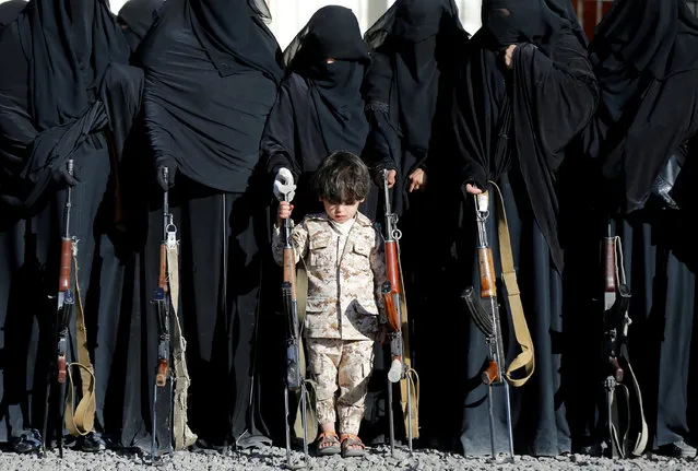 A boy stands with women loyal to the Houthi movement during a gathering held to show their support to the movement in Sanaa, Yemen January 14, 2018. (Photo by Khaled Abdullah/Reuters)