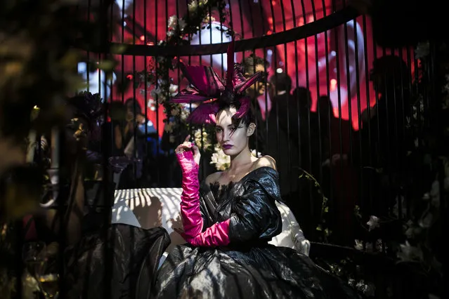 A performer sits in cage as she attends the “Grand Bal Christian Dior” during the Haute Couture Spring-Summer 2018 fashion collection presented in Paris, Monday, January 22, 2018. (Photo by Kamil Zihnioglu/AP Photo)