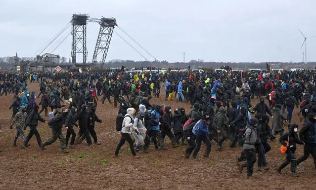 Protester take part in a large-scale protest to stop the demolition of the village Luetzerath to make way for an open-air coal mine extension on January 14, 2023. In an operation launched earlier this week, hundreds of police have been working to remove activists, who have already occupied the hamlet of Luetzerath in western Germany. (Photo by Ina Fassbender/AFP Photo)