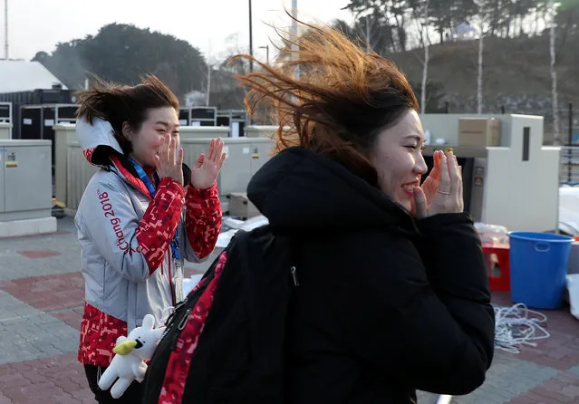 Women react in wind as they pass by a damaged security checkpoint that was blown over by the wind, February 14, 2018 at Gangneung Olympic Park in South Korea during the Pyeongchang Winter Olympics. (Photo by Damir Sagolj/Reuters)