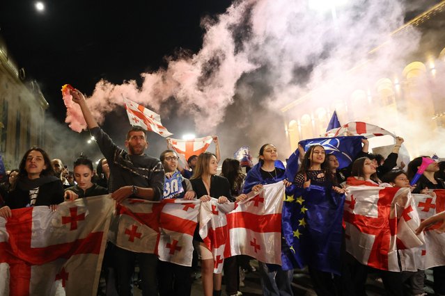 Protestors holding Georgian and European flags gather outside the parliament during a demonstration against a draft bill on “Foreign influence” in Tbilisi on April 21, 2024. Georgian youths have dominated a week of street protests since April 15, 2024, against plans for a “foreign influence” law and are increasingly vocal about affinity for the European Union and Western values. For the fifth straight night Friday, hundreds of young protesters marched in the capital Tbilisi to make their voices heard. (Photo by Giorgi Arjevanidze/AFP Photo)