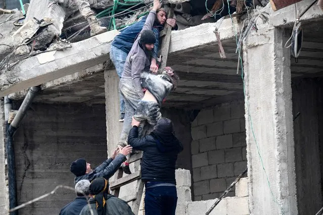 Residents retrieve an injured girl from the rubble of a collapsed building following an earthquake in the town of Jandaris, in the countryside of Syria's northwestern city of Afrin in the rebel-held part of Aleppo province, on February 6, 2023. Hundreds have been reportedly killed in north Syria after a 7.8-magnitude earthquake that originated in Turkey and was felt across neighbouring countries. (Photo by Rami Al Sayed/AFP Photo)