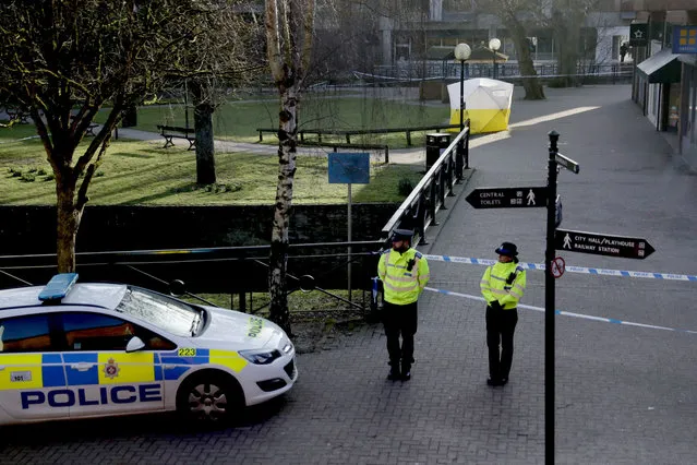 Police officers guard a cordon around a police tent covering the the spot where former Russian double agent Sergei Skripal and his daughter were found critically ill Sunday following exposure to an “unknown substance” in Salisbury, England, Wednesday, March 7, 2018. Britain's counterterrorism police took over an investigation Tuesday into the mysterious collapse of the former spy and his daughter, now fighting for their lives. The government pledged a “robust” response if suspicions of Russian state involvement are proven. Sergei Skripal and his daughter are in a critical condition after collapsing in the English city of Salisbury on Sunday. (Photo by Matt Dunham/AP Photo)