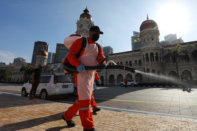 A worker sprays disinfectant at Independence Square during a disinfection operation, amid the coronavirus disease (COVID-19) outbreak in Kuala Lumpur on October 17, 2020. (Photo by Lim Huey Teng/Reuters)